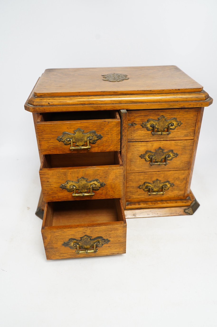An early 20th century oak collector's cabinet, retailer Fisher, 188 Strand, 38cm wide. Condition - fair